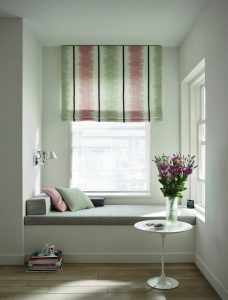 Fenster mit Sitzgelegenheit und buntem Rollo