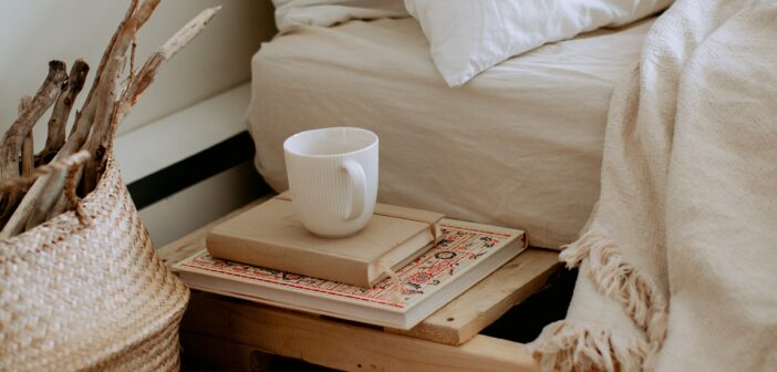 Bett mit Büchern und Kaffeebecher